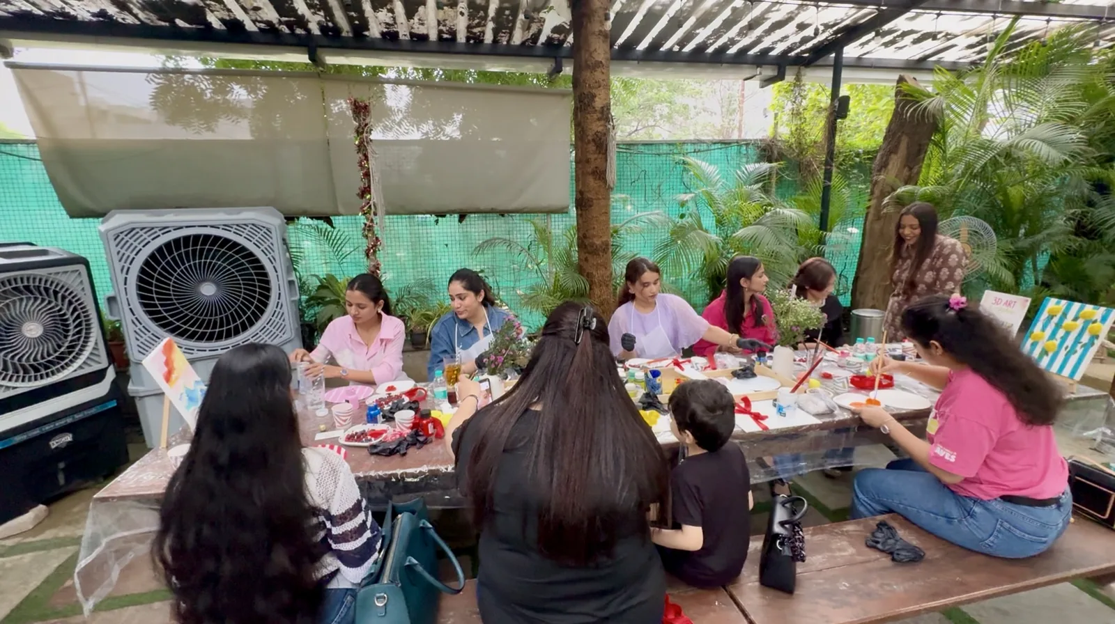 Participants painting together at the long table