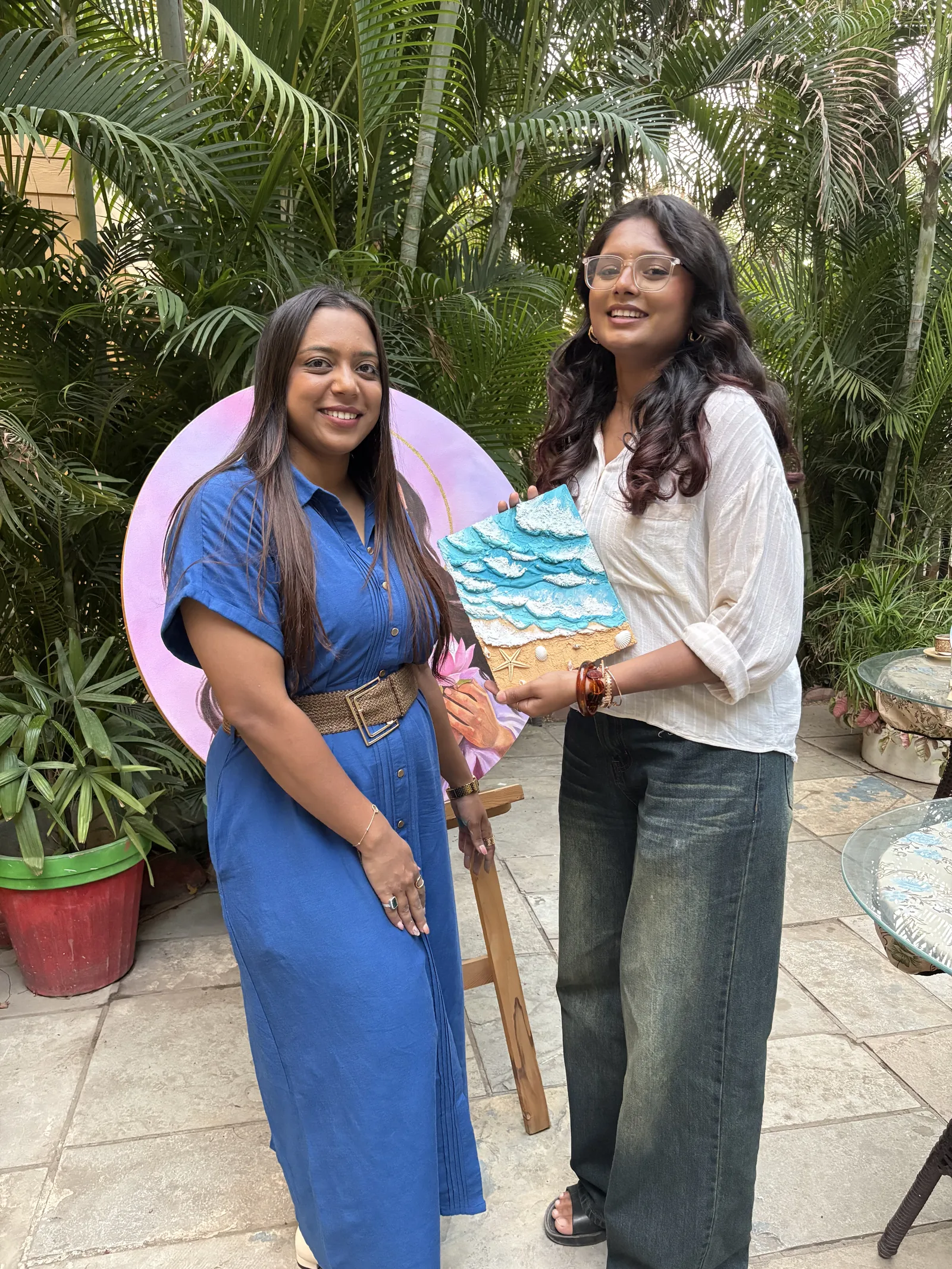 Two participants with their finished textured beach canvas