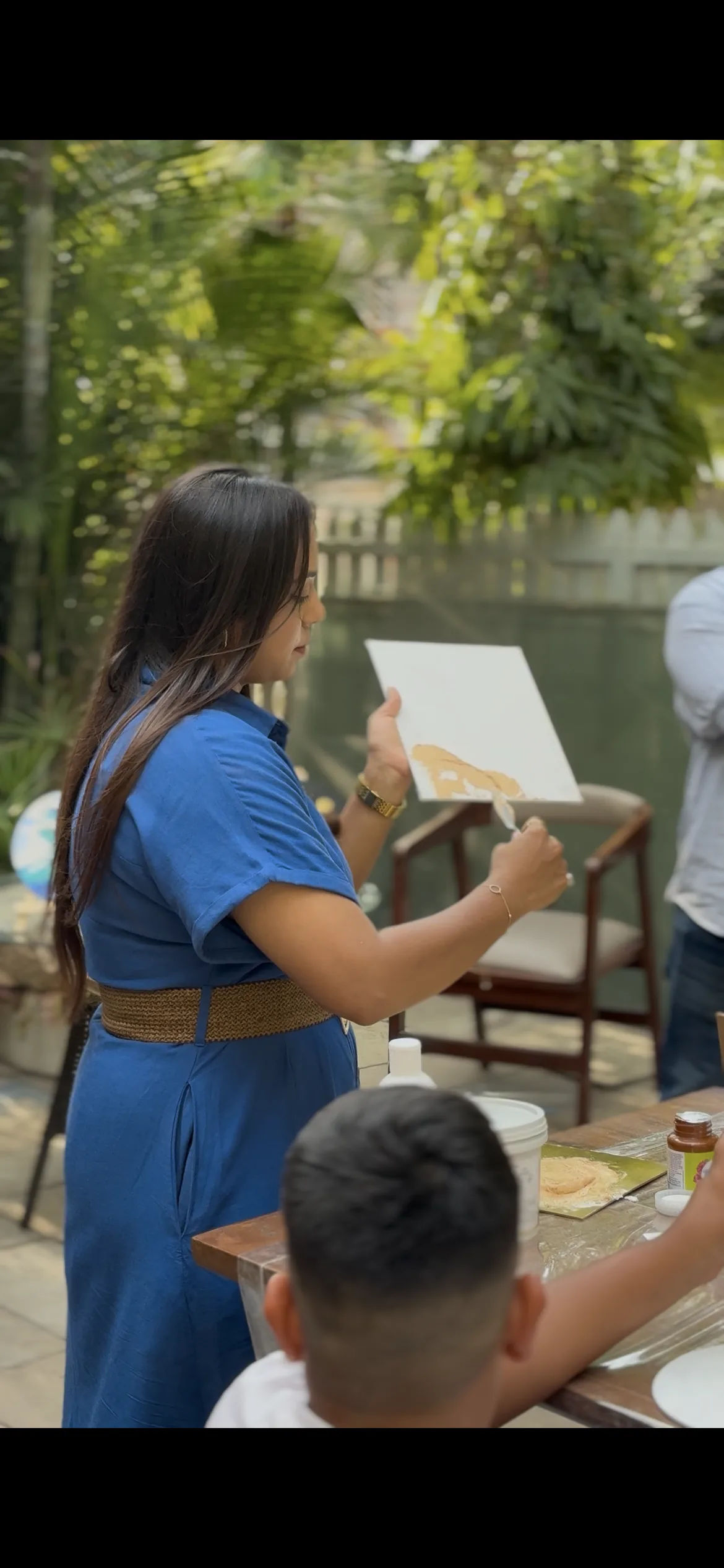 Jahnvi with participants and their finished canvases
